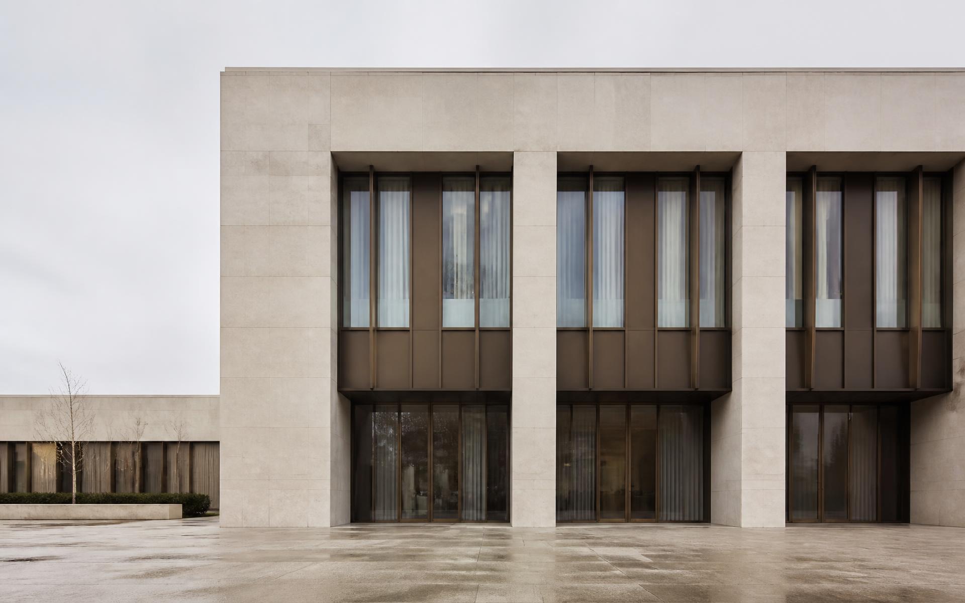 Stone and bronze facade of a contemporary building designed by the studio